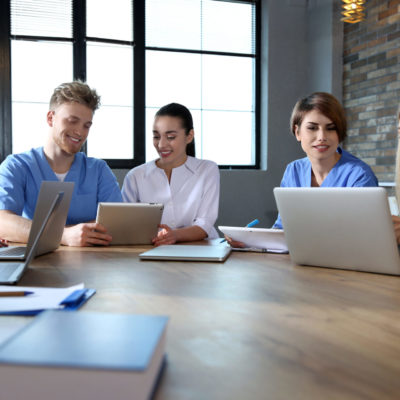 Group of smart medical students with gadgets in college Group of smart medical students with gadgets in college